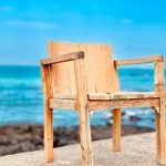 brown wooden chair near body of water