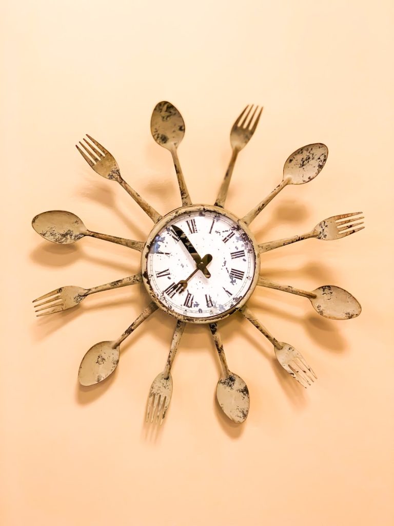 beige and white spoon and fork framed clock displaying 7:55