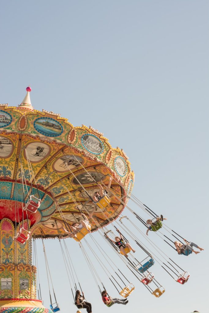 people riding on swing carousel during daytime