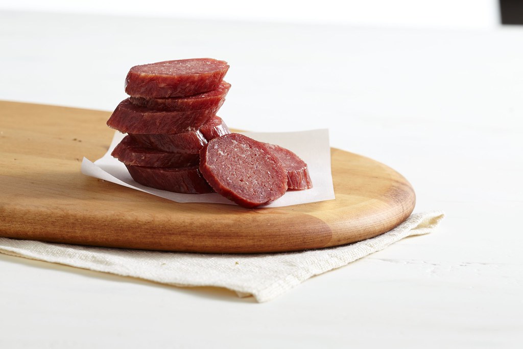 smoked meat salami slices on wood cutting board