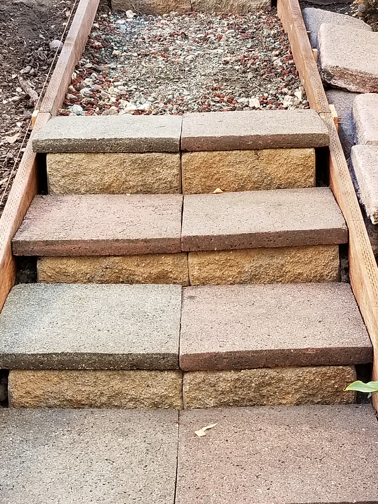 Retaining wall bricks and concrete pavers. With pressure treated wood as sides.