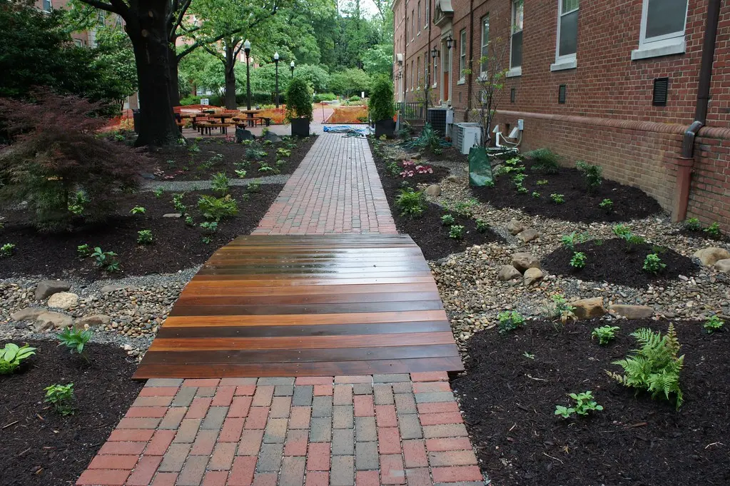 Yes. The image shows a well-designed backyard featuring brick pathways and landscaping, which is relevant to discussing the work of a hardscaping contractor.Artists' Backyard