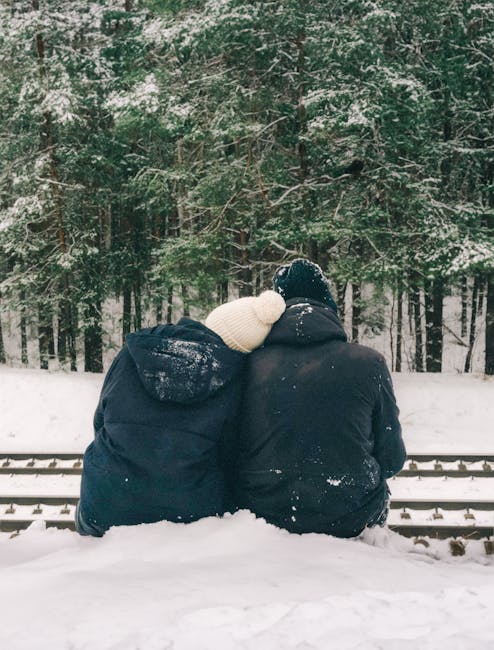 a couple of young men sitting by the railroad tracks