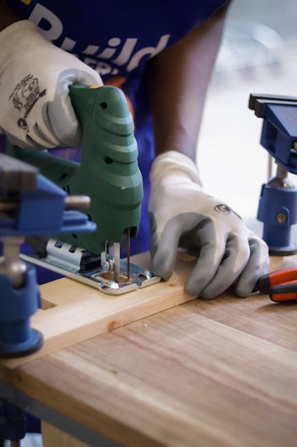 Carpenter using jigsaw power tool to cut wood.