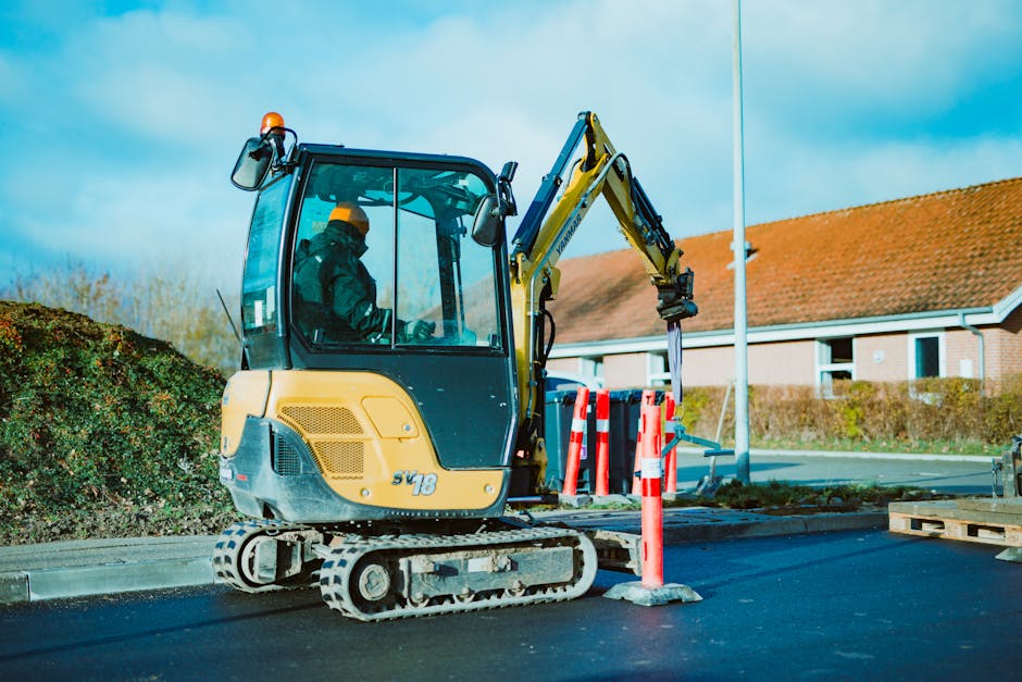 A person using a mini excavator in a landscaping project