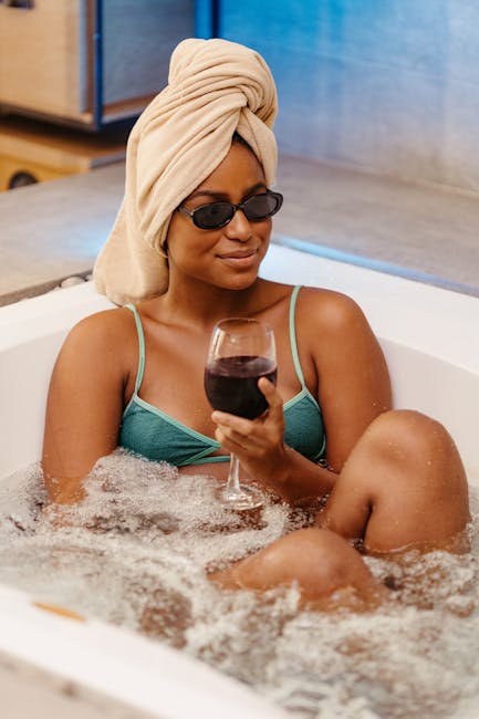 Types of Bedroom Jacuzzis Woman Lying in Jacuzzi with a Glass of Red Wine in her Hand 