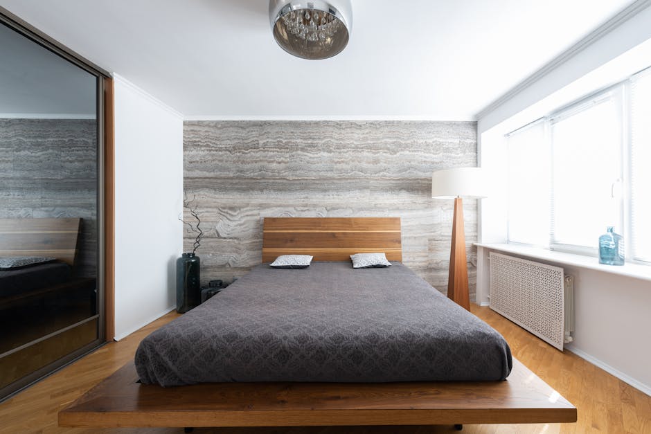 Light, floors, oak interior of light modern flat with bed near lamps on floor and ceiling near vases with leafless sprig near mirror wall and window with windowsill