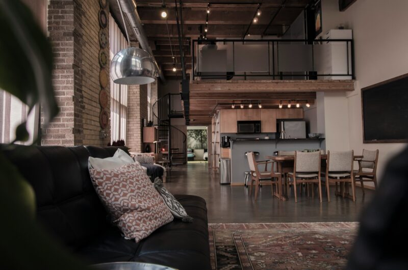 Black leather couch with gray throw pillow