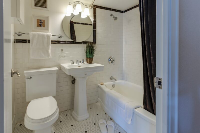 White Ceramic Toilet Bowl Beside Pedestal Sink