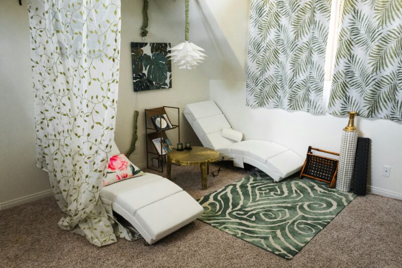 White and brown bed beside white and green floral curtain