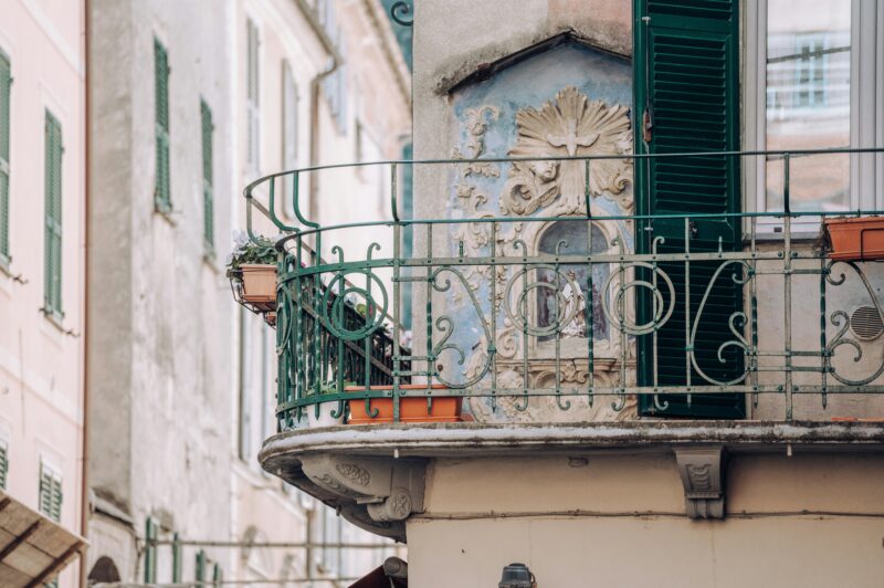 a balcony of a building with green shutters