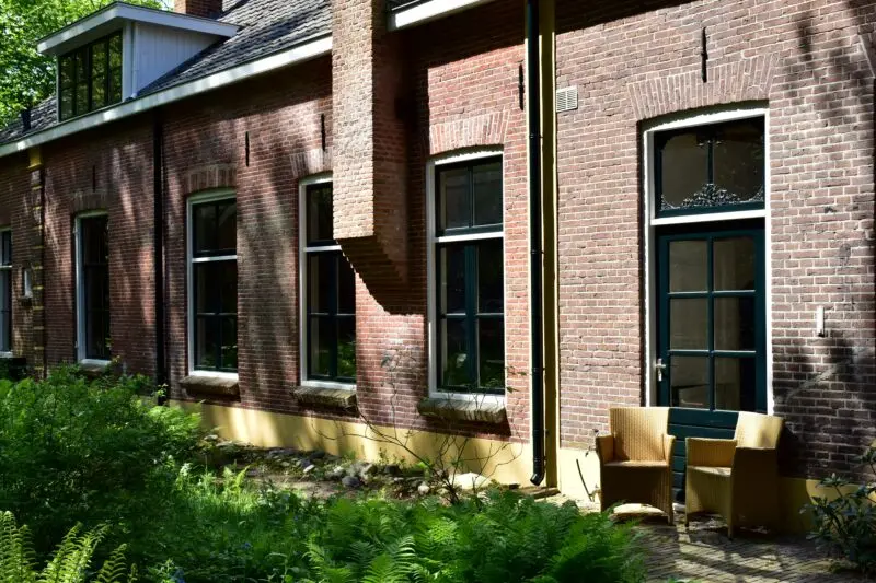 a brick building with lots of windows and a bench in front of it