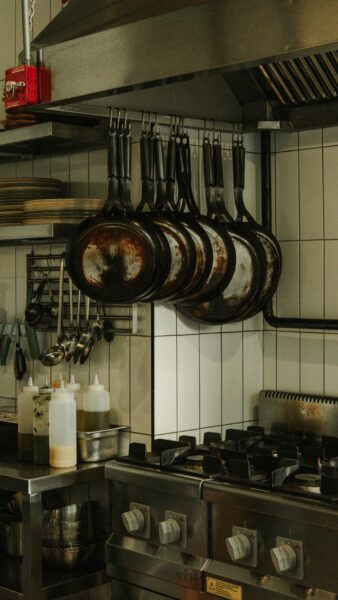 A kitchen with pots and pans hanging from the ceiling