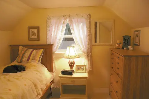 Home renovation of small upstairs north bedroom with grey cat, Nermal, on bed, in Seattle, Washington in the Crown Hill neighborhood. Simple styled honey oak dresser, by Modern Furniture, custom made, matching bedframe