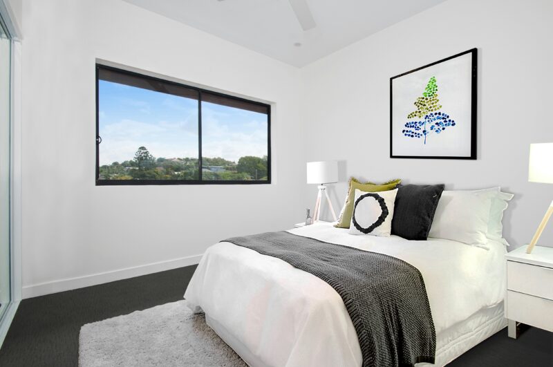 white bedspread on bed near window