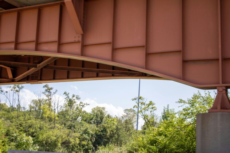 a bridge over a river with trees in the background