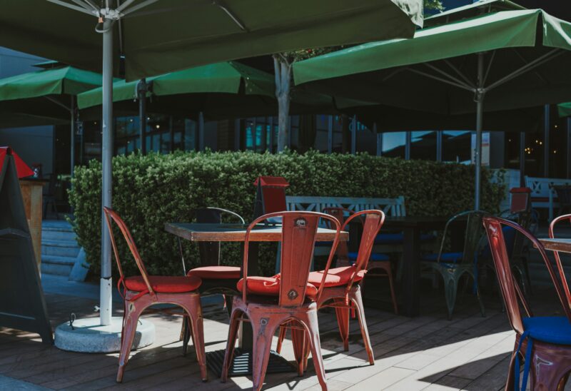 A group of tables and chairs under umbrellas