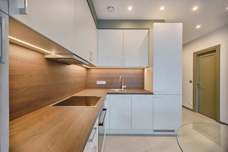 Modern kitchen interior with minimalistic design and wooden accents, captured with natural lighting.