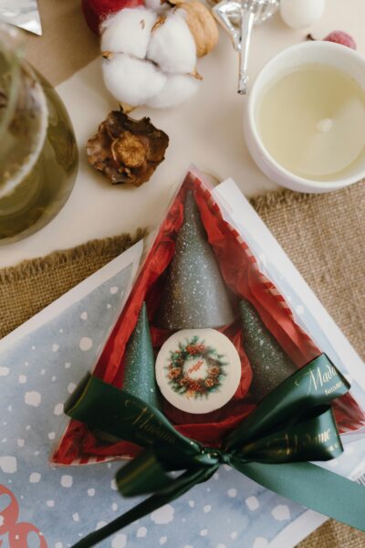 Christmas-themed gift package and candle with holiday decor.