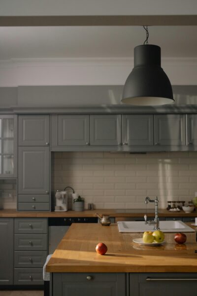 Stylish modern kitchen interior with gray cabinets and wooden countertops.