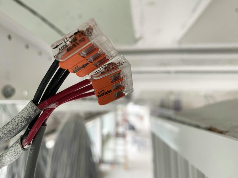 Detailed view of splicing connectors and wires in an indoor setting, ideal for technology-related projects.