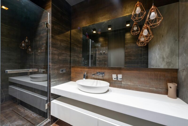 A sleek modern bathroom featuring pendant lighting and a contemporary sink.