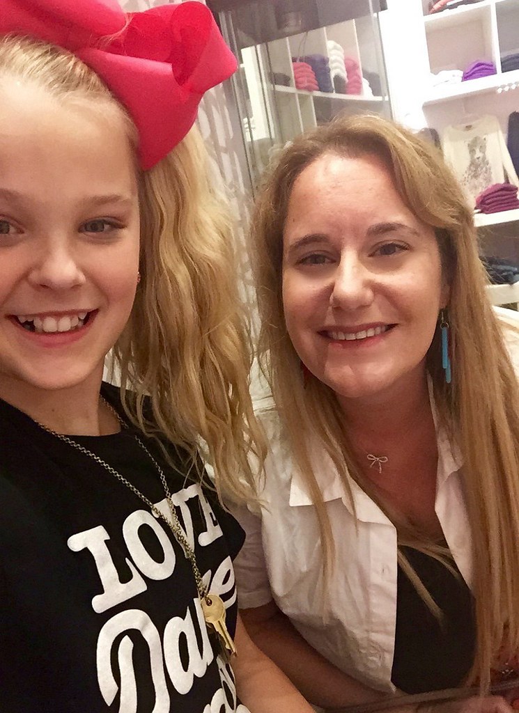 JoJo Siwa with a fan, smiling at camera