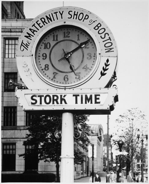 Symbols - Daytime, Clock - Maternity Shop of Boston, Close-up of Clock with Leaf Motif and 'STORK TIME' on Pole on Sidewalk, Stone Facade Buildings, Firebox, One-way Sign