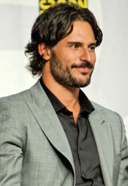 Joe Manganiello speaking at a convention in a suit