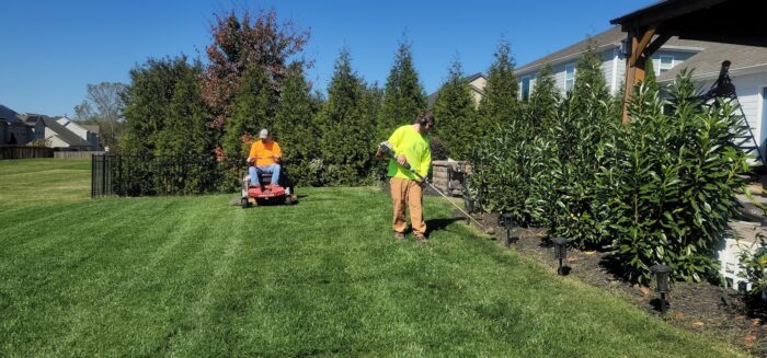 A man mowing a lawn with a lawn mower