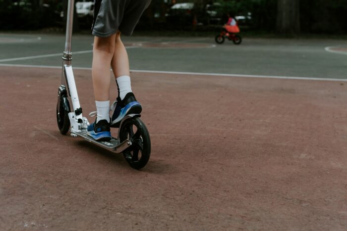 person in black and white nike sneakers riding blue and white skateboard during daytime