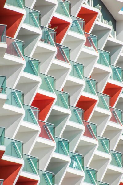 Abstract view of a contemporary building's geometric facade in Dubai with red and teal accents.