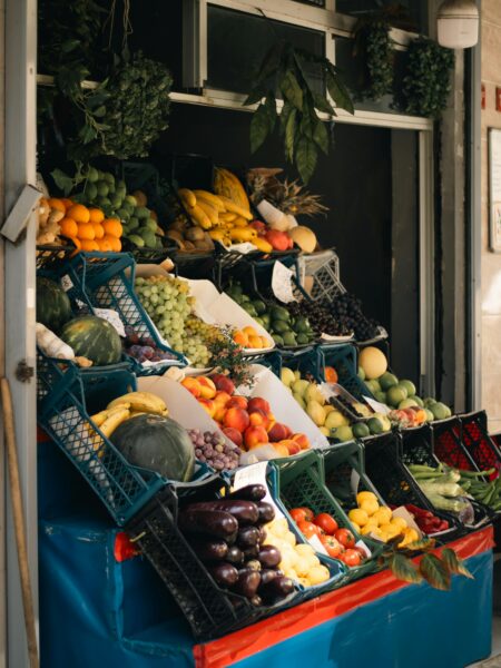 A vibrant array of fresh fruits and vegetables displayed at an outdoor market stall.