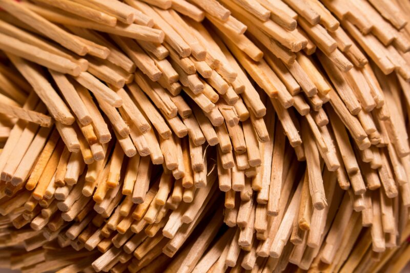 Closeup texture of stacked wooden thin sticks with uneven surface placed as abstract background