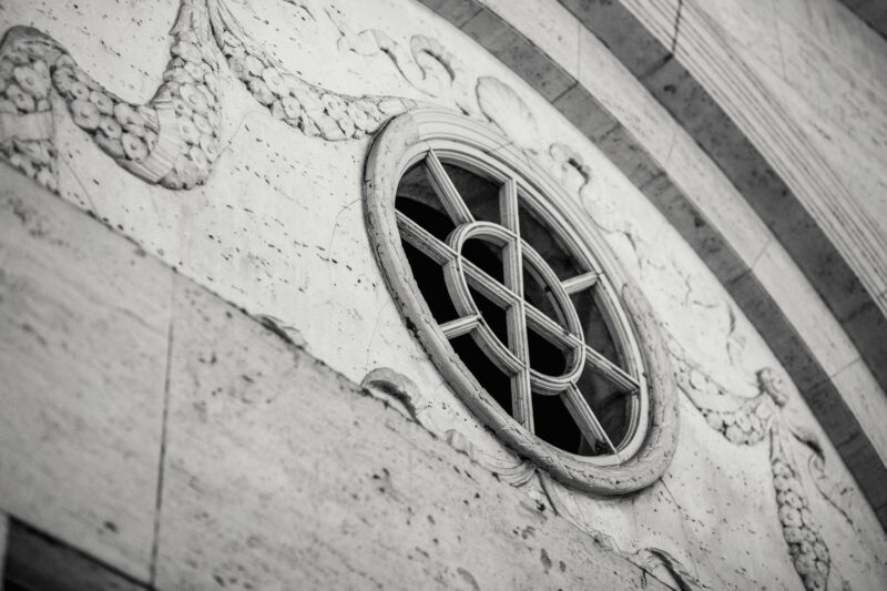 Black and white close-up of ornate historic stone facade with decorative window