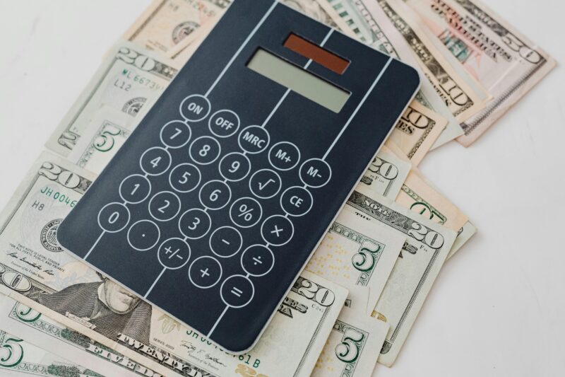 Close-up of a calculator atop US dollar bills, symbolizing financial planning and budgeting.