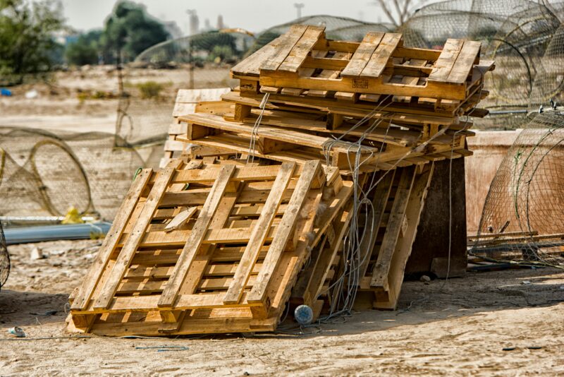 Rustic stack of wooden pallets with wire mesh outdoors in Al Jahra, Kuwait.