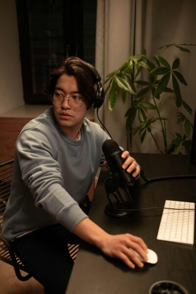 Asian man podcast recording, home desk setup, microphone