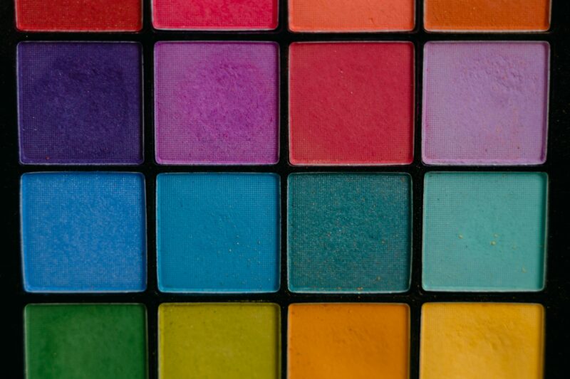 A close-up of a vibrant and colorful eye shadow palette featuring multiple shades, perfect for makeup enthusiasts.