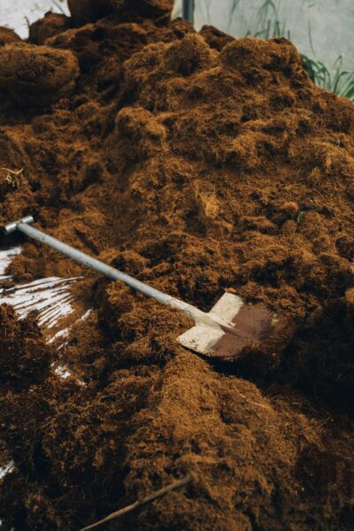 A shovel resting on a pile of nutrient-rich soil, ideal for gardening and planting.