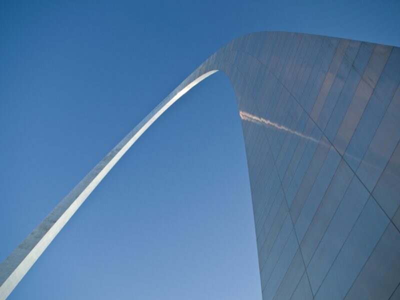 A stunning low-angle view of the Gateway Arch with a clear blue sky in St. Louis.