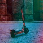 black and red kick scooter on brown concrete floor