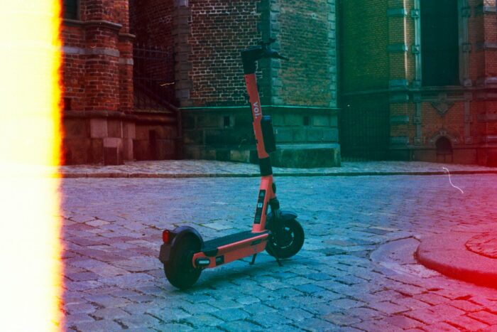 black and red kick scooter on brown concrete floor