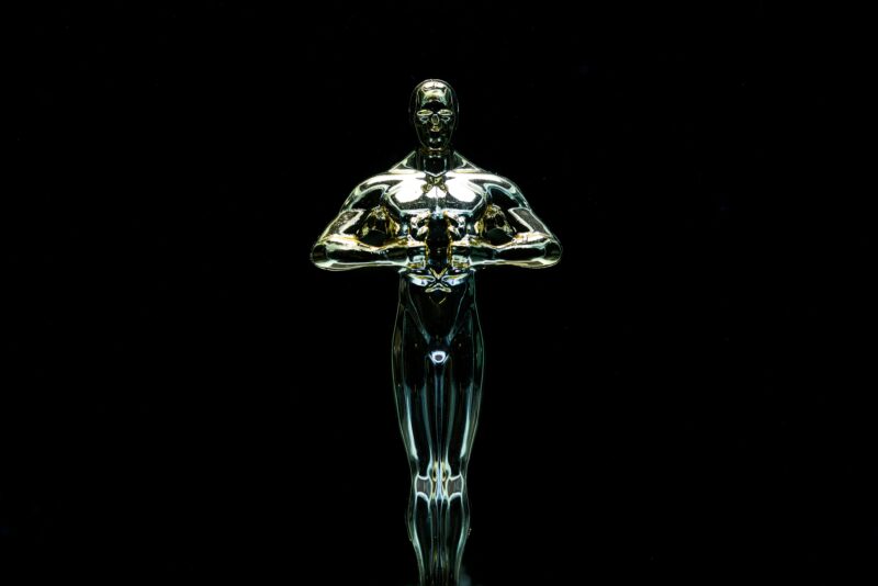 A golden trophy statue isolated on a black background symbolizing achievement and victory.