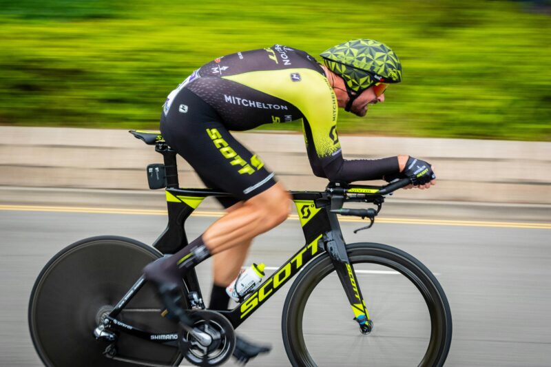 A focused cyclist speeds down the road during a competitive race, showcasing athleticism and precision.