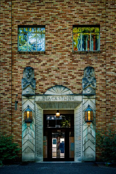 Exterior view of Blackstone building entrance with Art Deco design and sculptures.