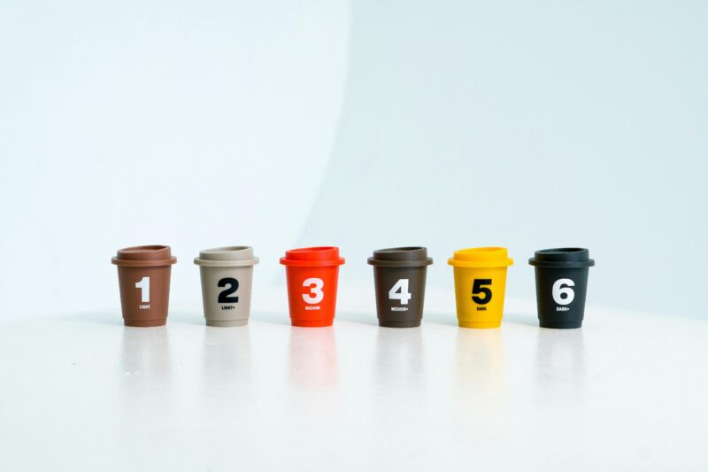 A set of colorful toy cups labeled from 1 to 6, aligned in a row on a white surface.