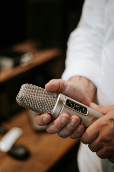 A man holding a studio microphone, perfect for podcast and audio recording themes.