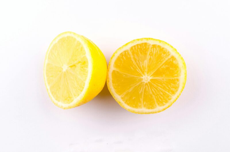 Close-up of fresh, juicy lemon halves on a clean white background.