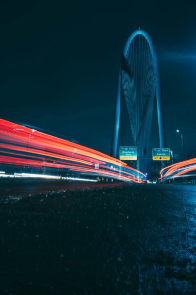 Long exposure of light streaks under the Margaret Hunt Hill Bridge in Dallas, Texas at night.